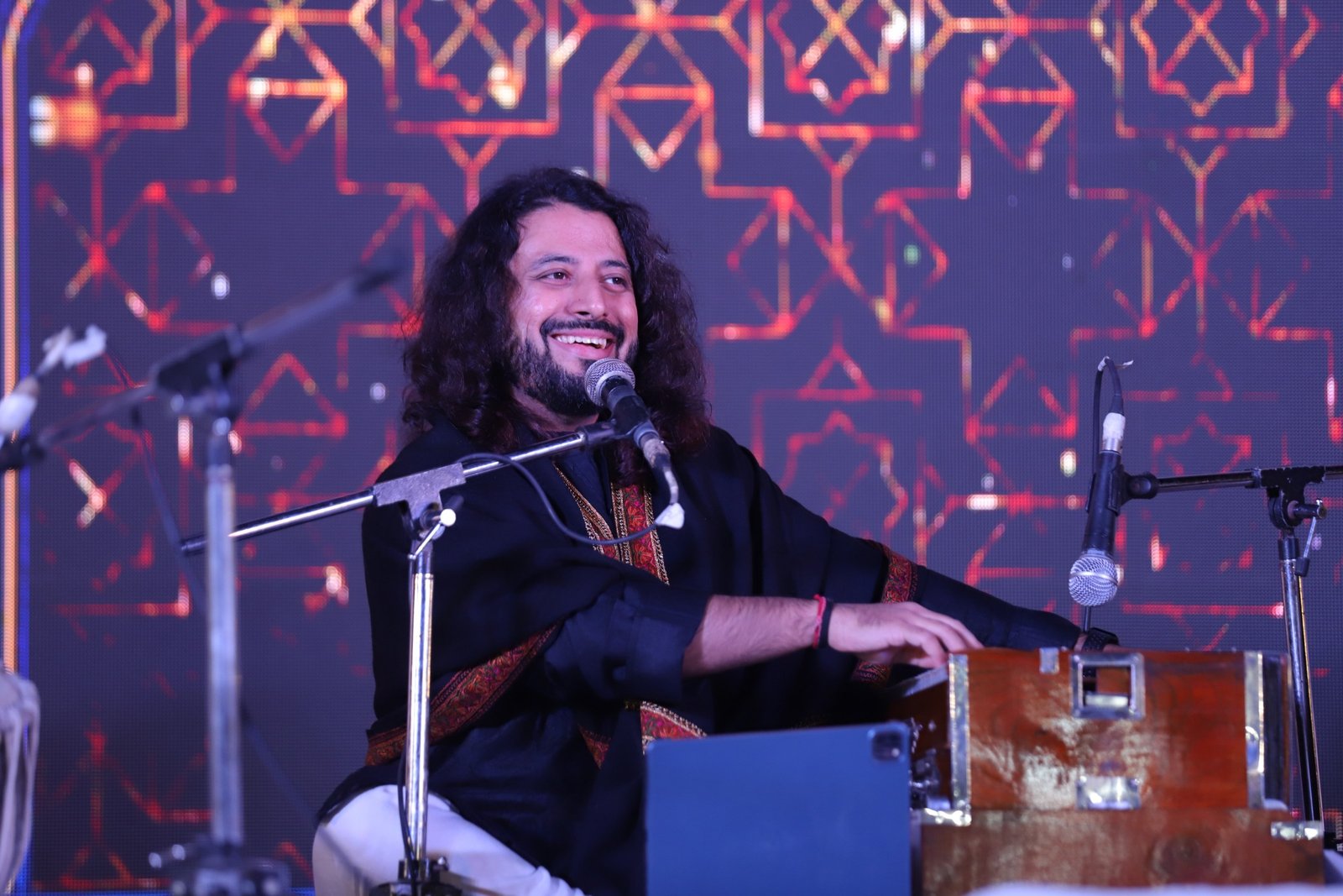 Saurabh Zadoo singing at the harmonium under stage light